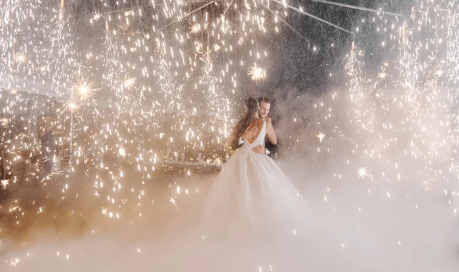 Bride dancing amid fireworks and smoke at the reception
